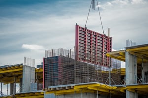 Ein industrielles Bauelement wird in eine Stahlkonstruktion eingehoben – Symbol für die Entstehung einer skalierbaren Unternehmensplattform.